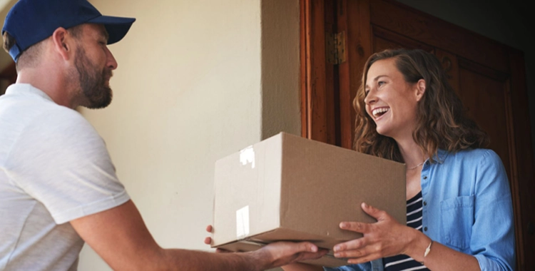 Frau nimmt glücklich ihr Versandpaket entgenen